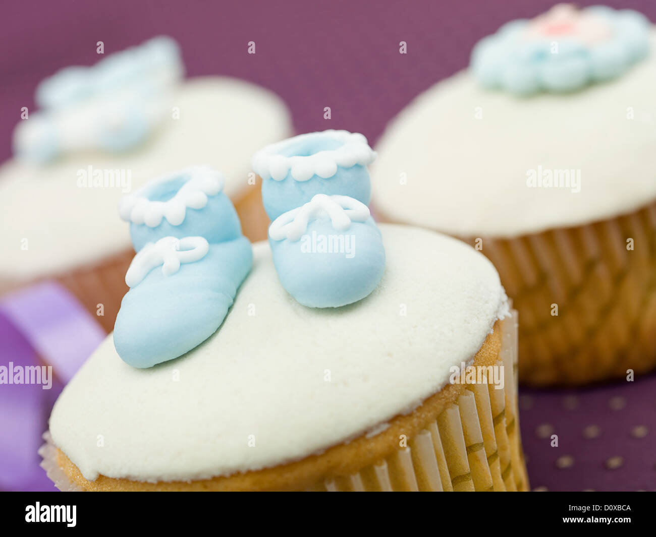 Trois des muffins pour les nouveau-nés en premier plan de vacances chaussons bleu fond violet Banque D'Images