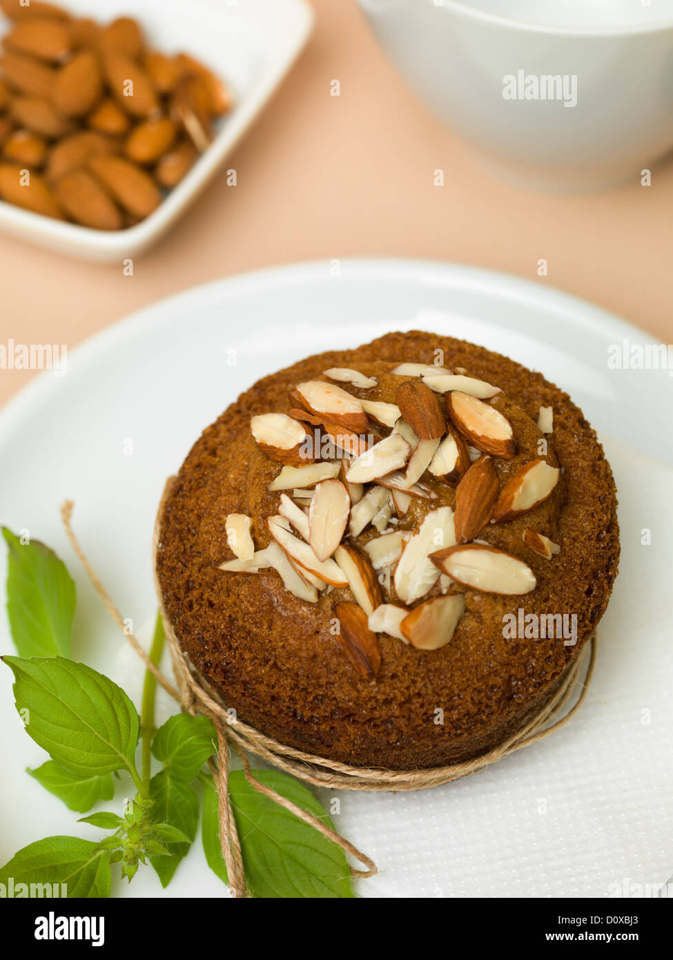 Chocolat muffins aux amandes sur plaque blanche décorée de verdure attaché avec une corde sur fond beige Banque D'Images