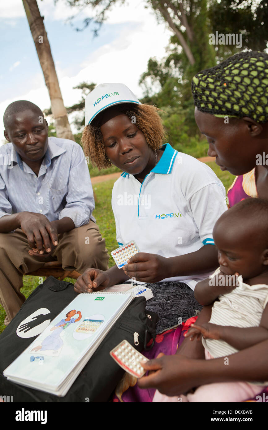 Un travailleur en santé communautaire traite de la planification familiale et la contraception avec une famille sur l'île de Bussi, Ouganda, Afrique de l'Est. Banque D'Images