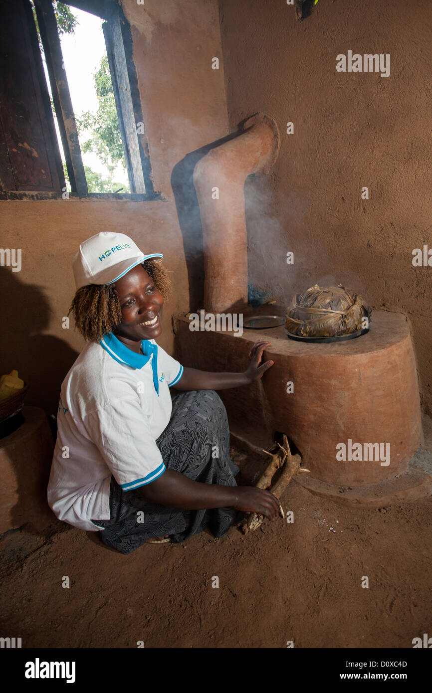 Une femme utilise une cuisinière à économie d'énergie dans sa cuisine sur Bussi Island, Ouganda, Afrique de l'Est Banque D'Images