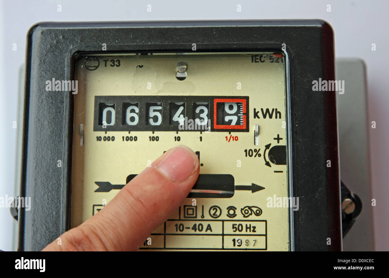 Doigt d'un homme indiquant les chiffres d'un compteur d'énergie électrique Banque D'Images