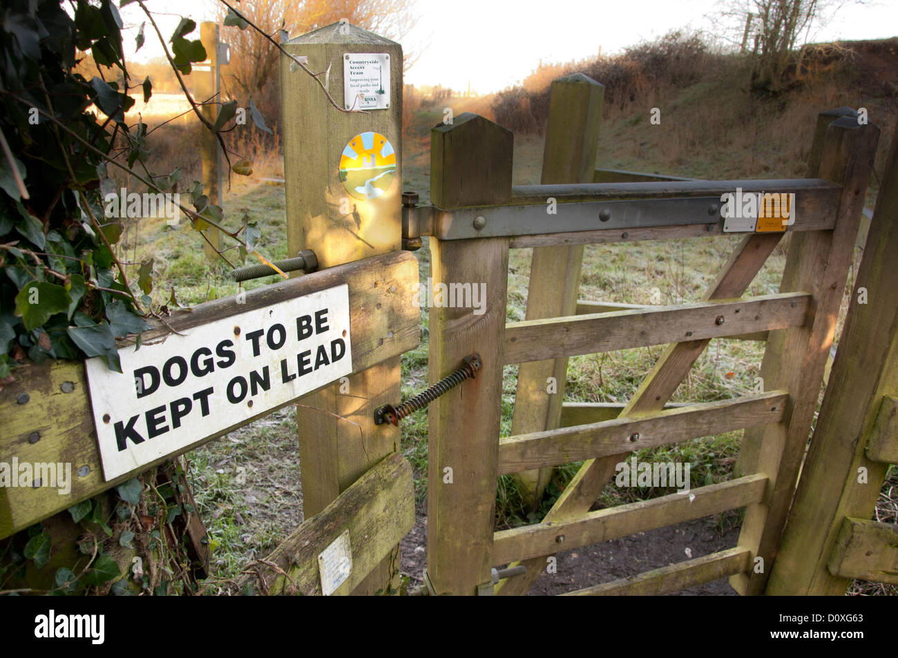 Les chiens à être tenu sur le plomb signe sur chemin de pays Banque D'Images