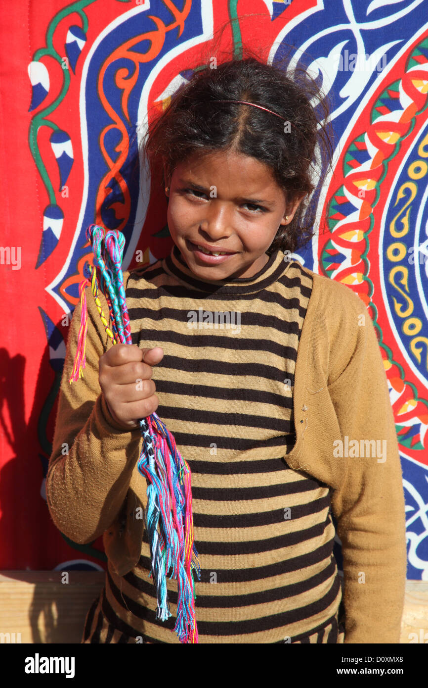 DAHAB - JANVIER 23. Jeune vendeur de rue exhibant ses bracelets à Dahab, Egypte. Il fournit un revenu pour leur famille. Banque D'Images