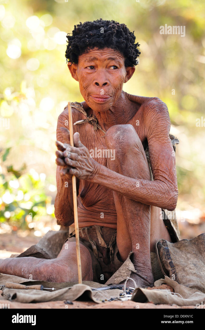 Bushmen Afrique Namibie aîné clan Portrait naturel vieux chasseurs-cueilleurs nomades primitifs âgés assis tribu outils Banque D'Images