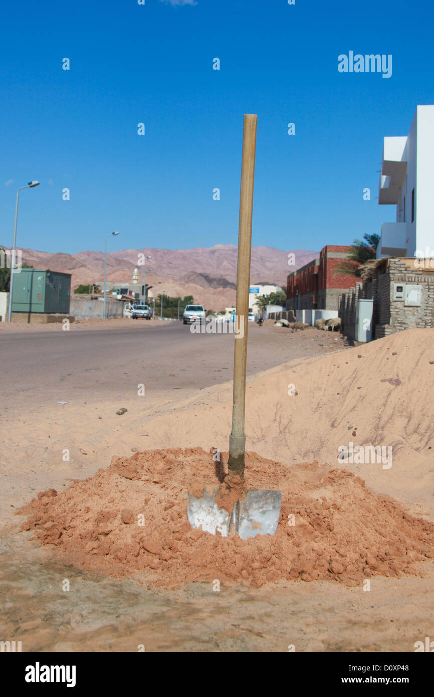 Spade et mélange de sable, de ciment dans les rues de Dahab en Egypte Banque D'Images