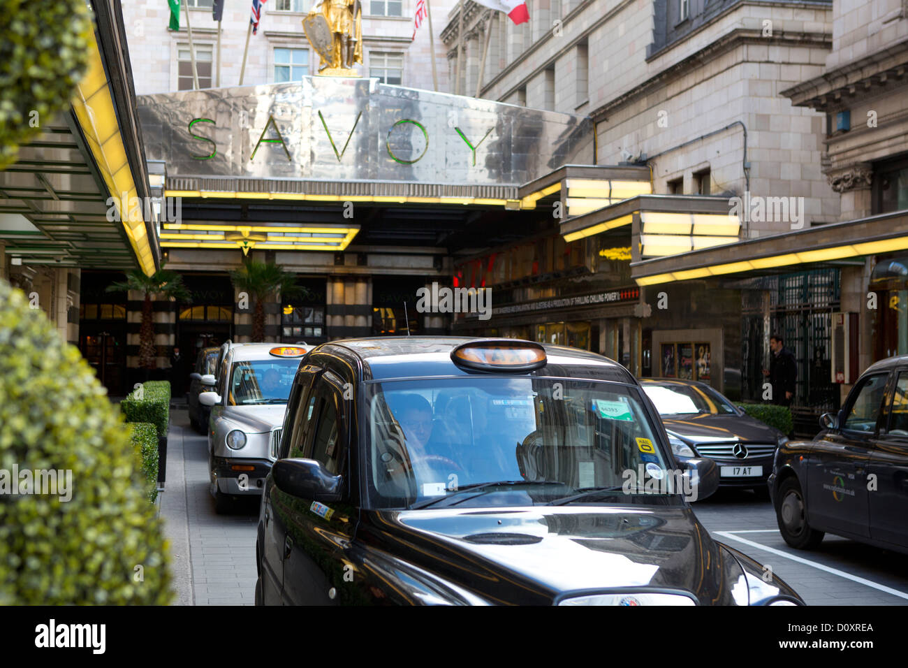 Black taxi à l'extérieur de l'hôtel Savoy de Londres. Banque D'Images