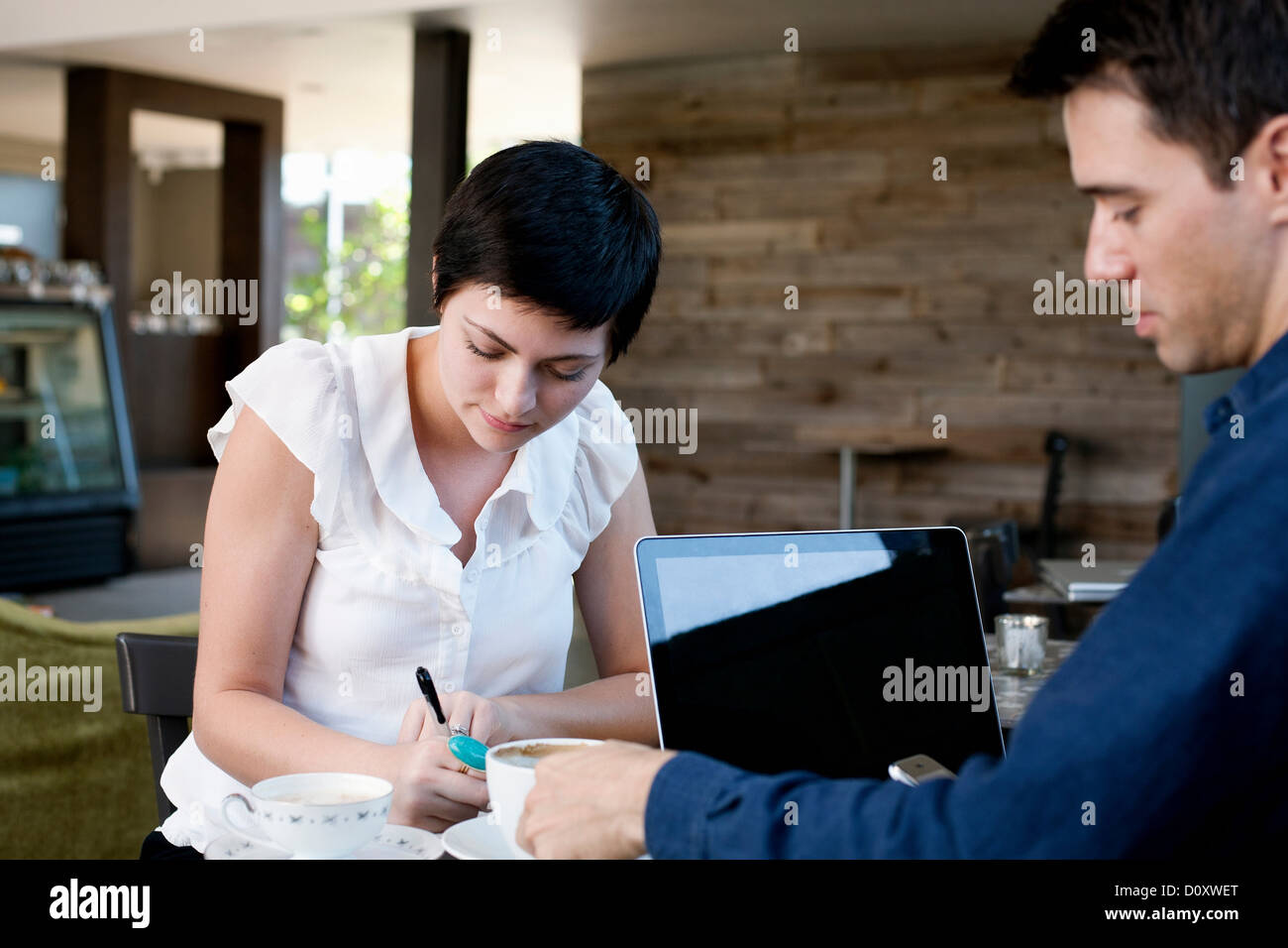 La femme et l'homme travaillant dans un café Banque D'Images