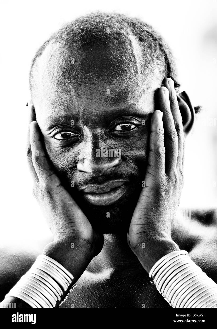 Portrait noir et blanc d'un homme de la tribu Karo tenait la tête, Korcho Village, Ethiopie Banque D'Images