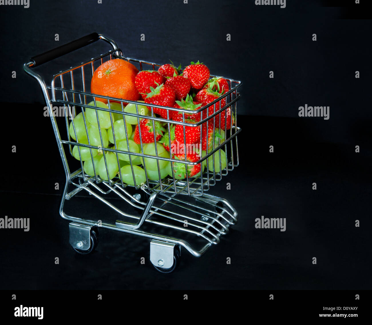 Panier plein de fruits frais et sain sur fond sombre Banque D'Images