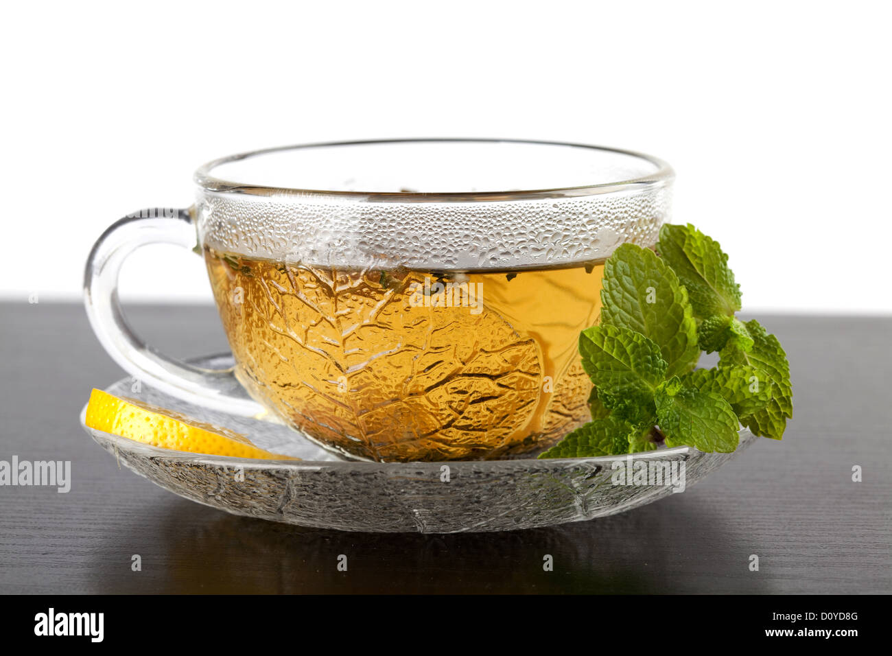 Tasse de thé vert avec du citron et de la menthe sur la table en bois sombre. Banque D'Images