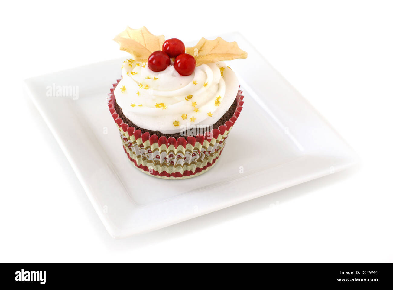 Glaçage à la vanille Cupcake décoré de houx avec couleur or et rouge feuilles fondantes bonbons. Banque D'Images