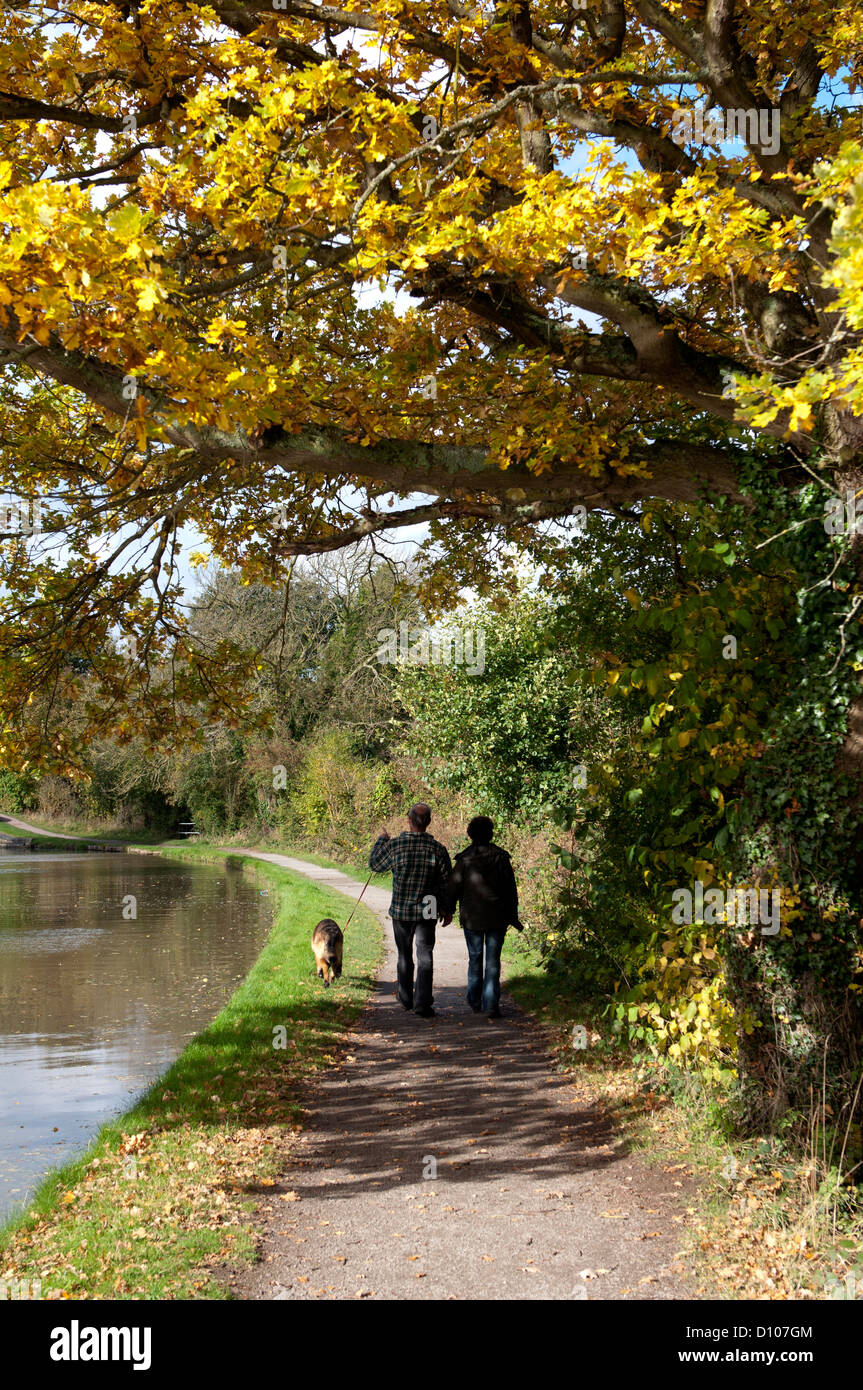 Couple en train de marcher sur le chemin de halage du canal en automne Banque D'Images