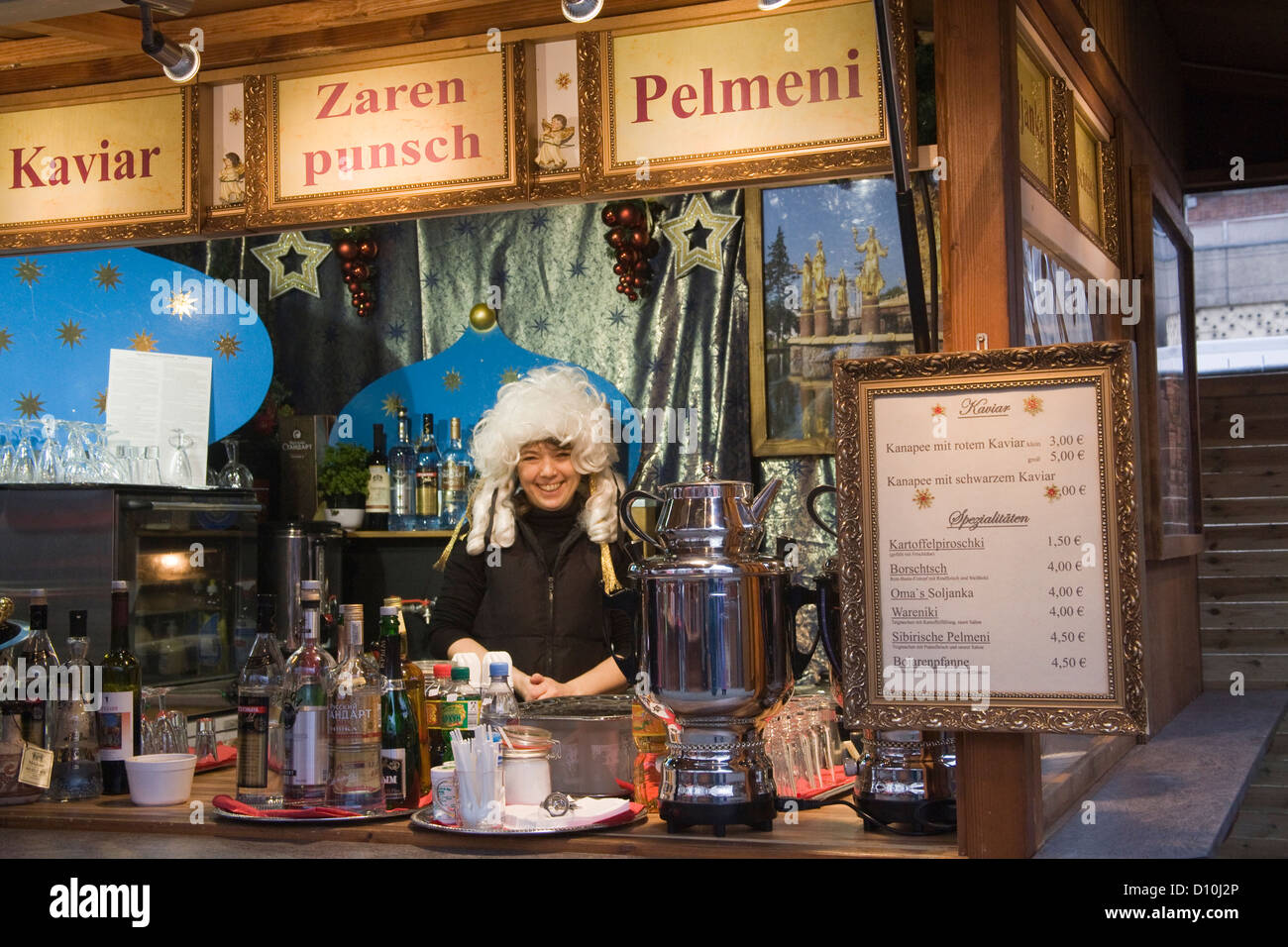 Berlin Allemagne UE novembre souriante jeune femme en perruque blanche manning food au Marché de Noël Banque D'Images