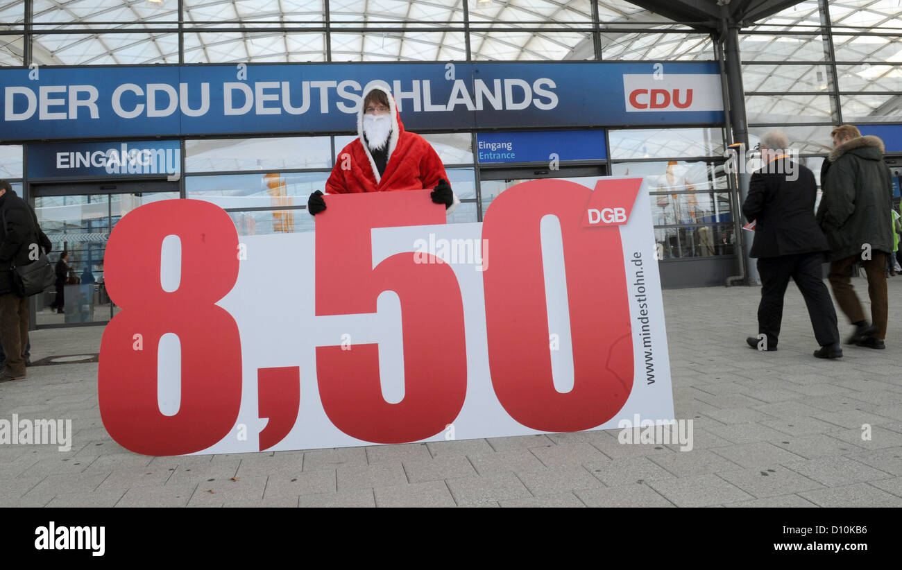 Un membre de la DGB, la Fédération des Syndicats Allemands, les peuplements avec un signe qui se lit '8,50' en face du centre des congrès où le 25e Congrès du Parti fédéral de la démocrate-chrétienne (CDU) se déroule à Hanovre, Allemagne, le 4 décembre 2012. La manifestation attire l'attention sur la demande de l'introduction du salaire minimum en Allemagne. Photo : Jochen Luebke Banque D'Images