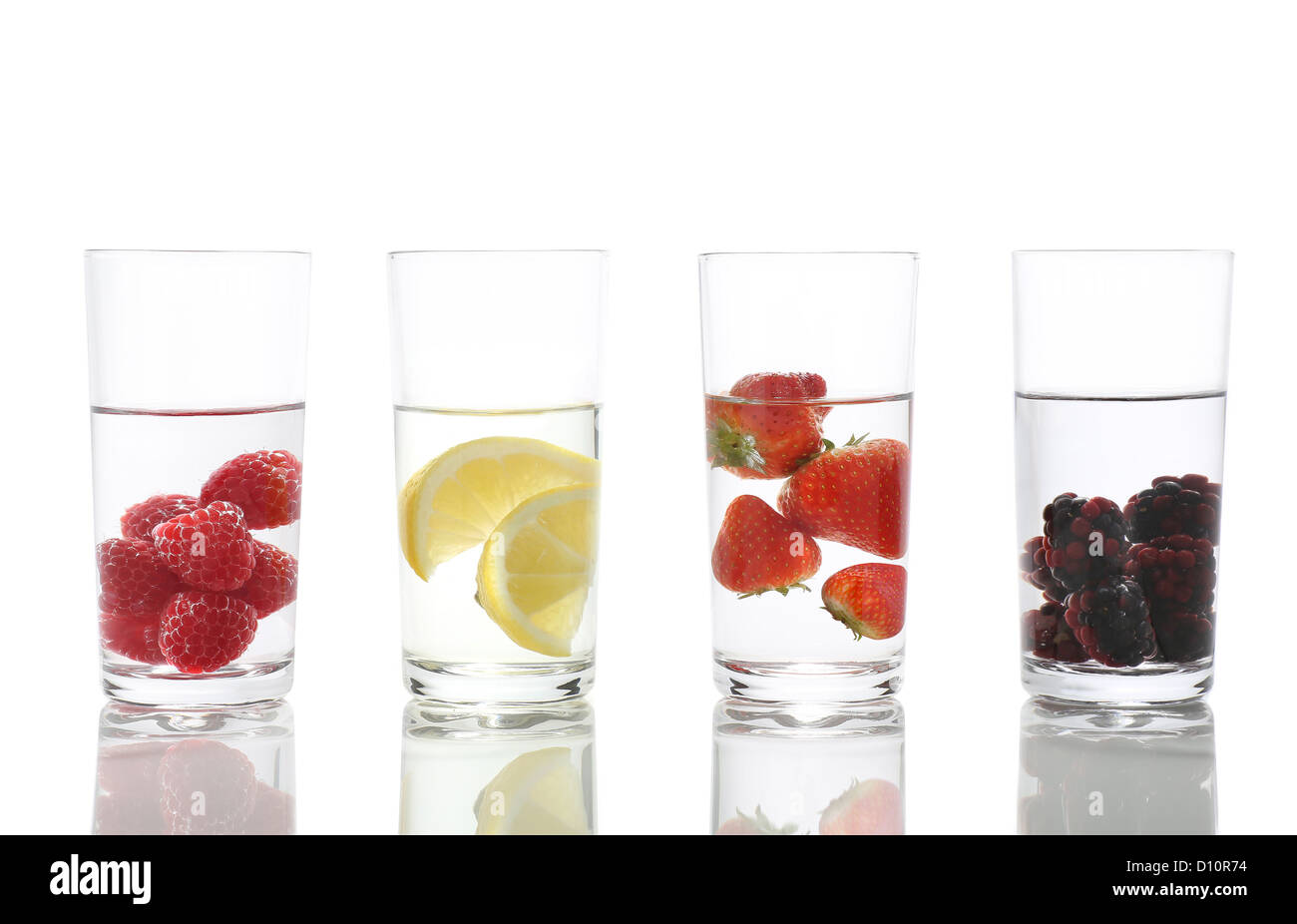Quatre grands verres d'eau à saveur de fruits contenant chacun leur goût de fruits, sur blanc avec réflexion. Banque D'Images