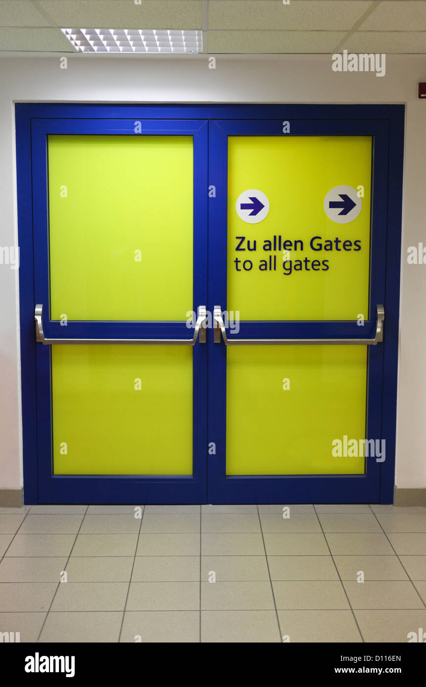 Porte avec panneau à donner des directions de l'aéroport passagers Banque D'Images