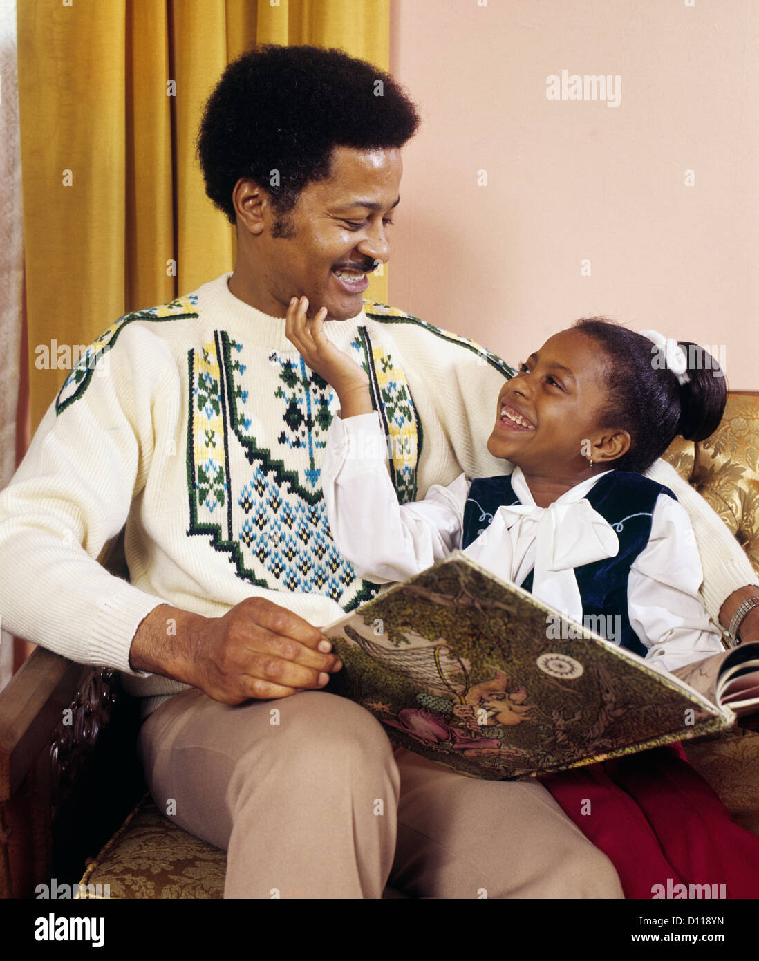 1970 professionnels africains-américains père et fille lire un livre Banque D'Images