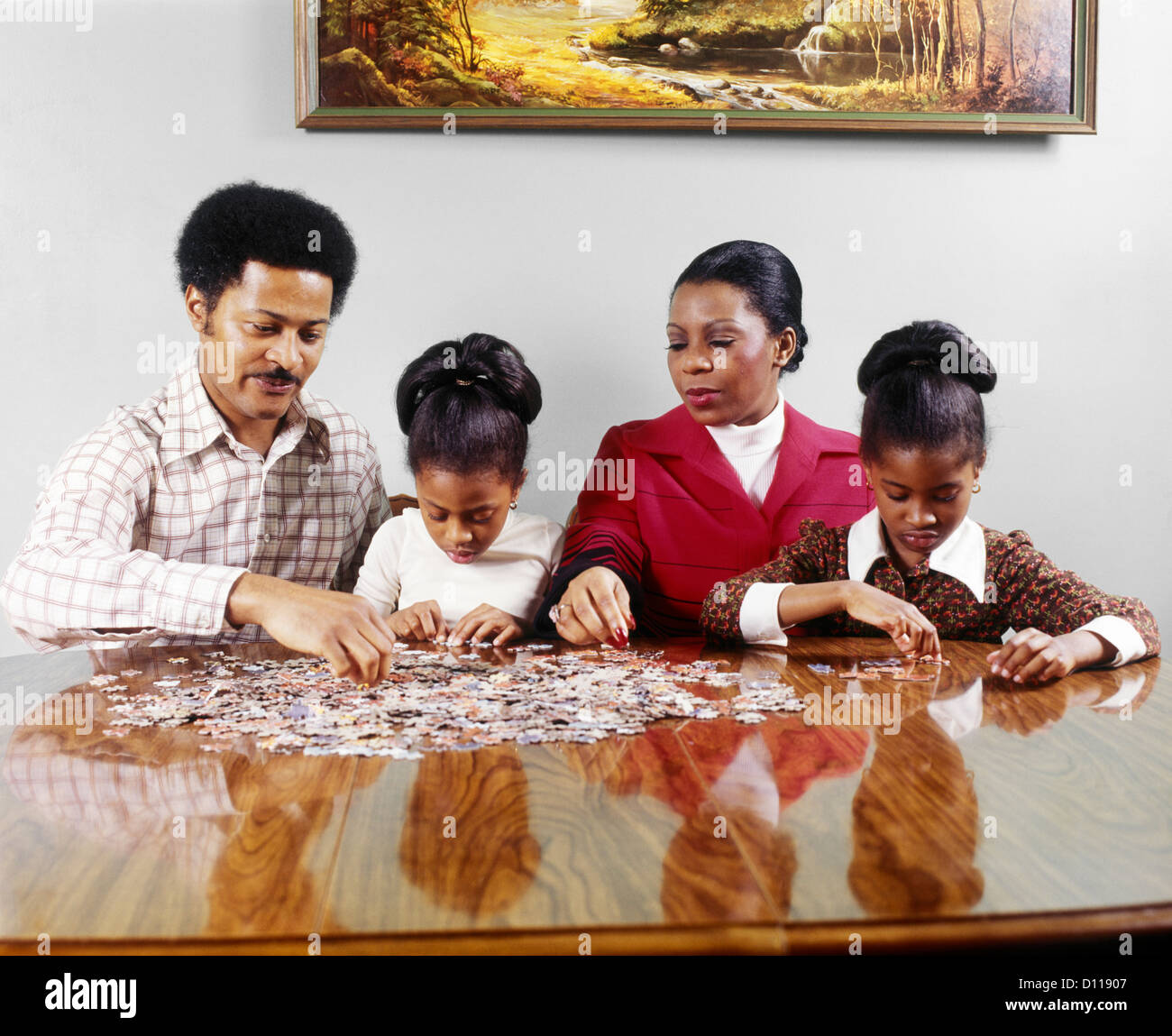 1970 AFRICAN AMERICAN FAMILY PÈRE MÈRE DEUX FILLES SITTING AT TABLE FAISANT Jigsaw Puzzle Banque D'Images