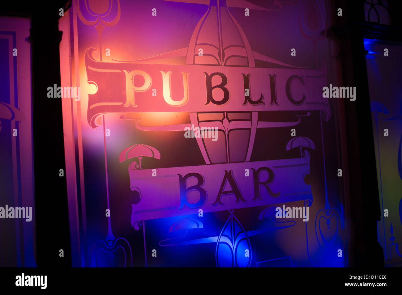 La lumière colorée qui brillait à travers la fenêtre en verre gravé au public bar d'un pub, extérieur, nuit, UK Banque D'Images