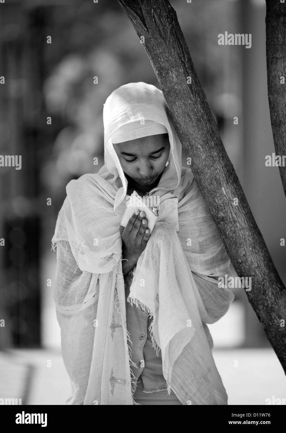 Le noir et blanc Portrait d'une femme orthodoxe priant avec une Bible, Harar, en Ethiopie Banque D'Images