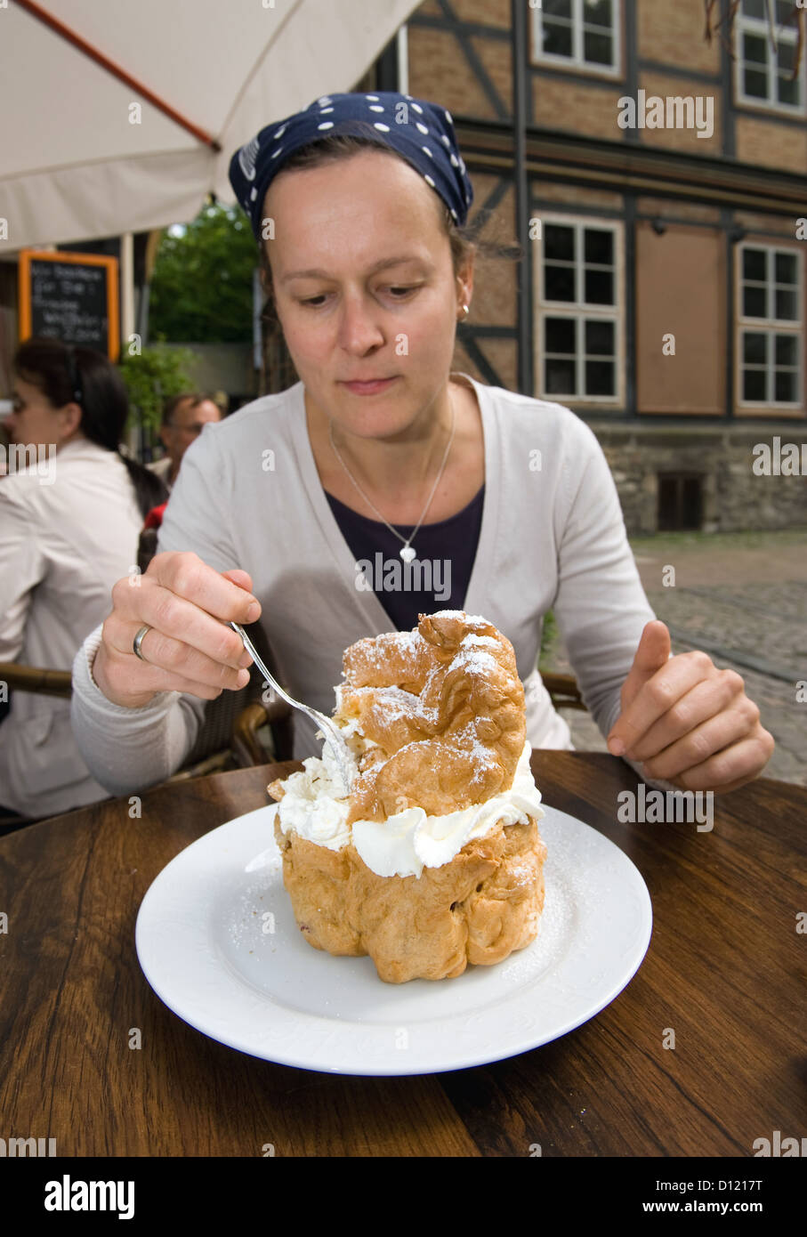 Goslar, Allemagne, une femme de manger avec de la crème et bouffées géant cerises Banque D'Images