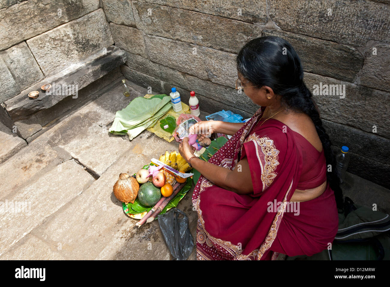 Femme faisant une offrande rituelle. Sanctuaire hindou. La ville ancienne de Polonnaruwa. Sri Lanka Banque D'Images