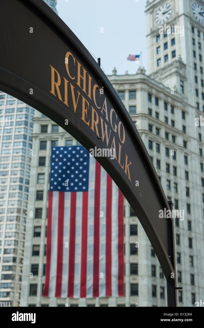 Un drapeau américain les mains sur le côté d'un bâtiment avec le signe de la Riverwalk Chicago, Chicago, Illinois, États-Unis Banque D'Images