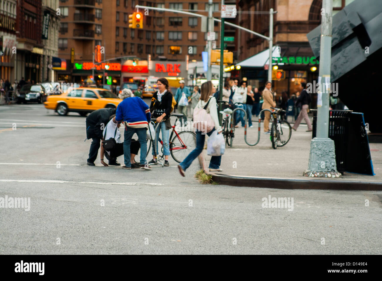 Des gens qui aident d'une personne qui s'est déclenché. Manhattan, New York, NY, USA Banque D'Images