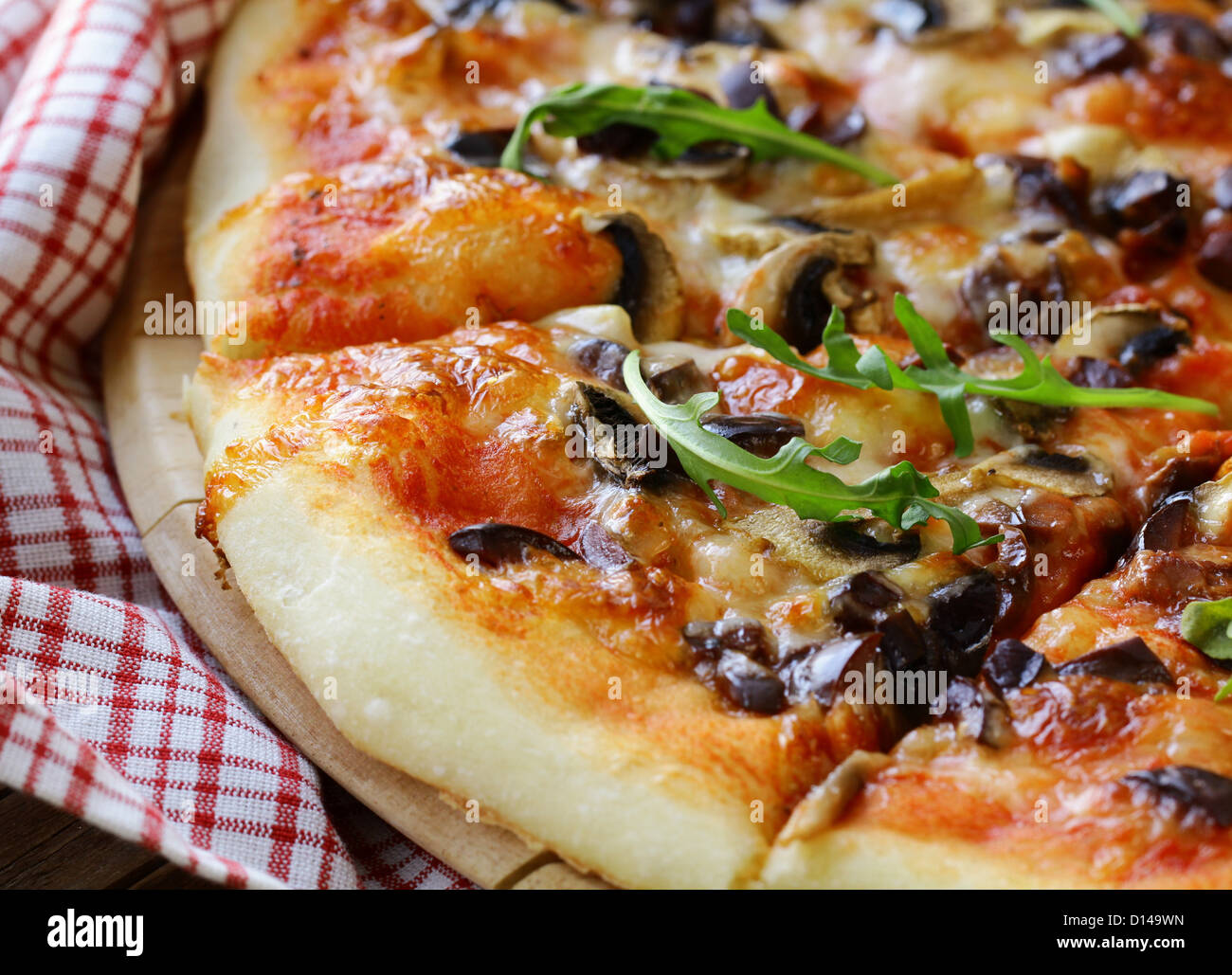 Pizza italienne avec des champignons et des olives sur une planche en bois Banque D'Images