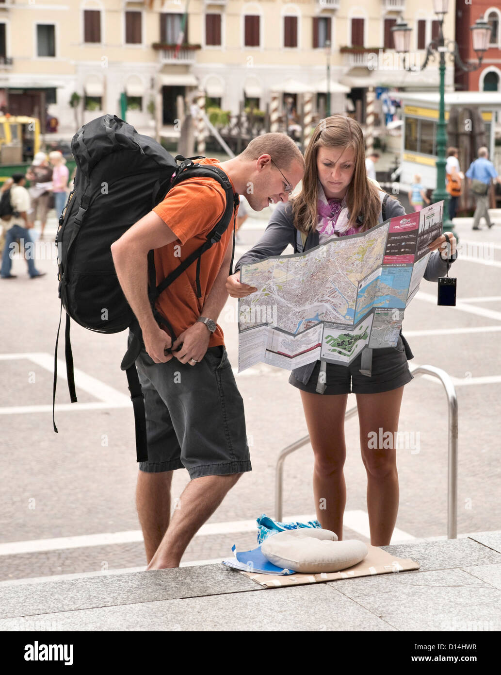 Jeune couple backpacking lire la carte, à l'extérieur du terminus ferroviaire Santa Lucia de Venise, Ferrovia Banque D'Images