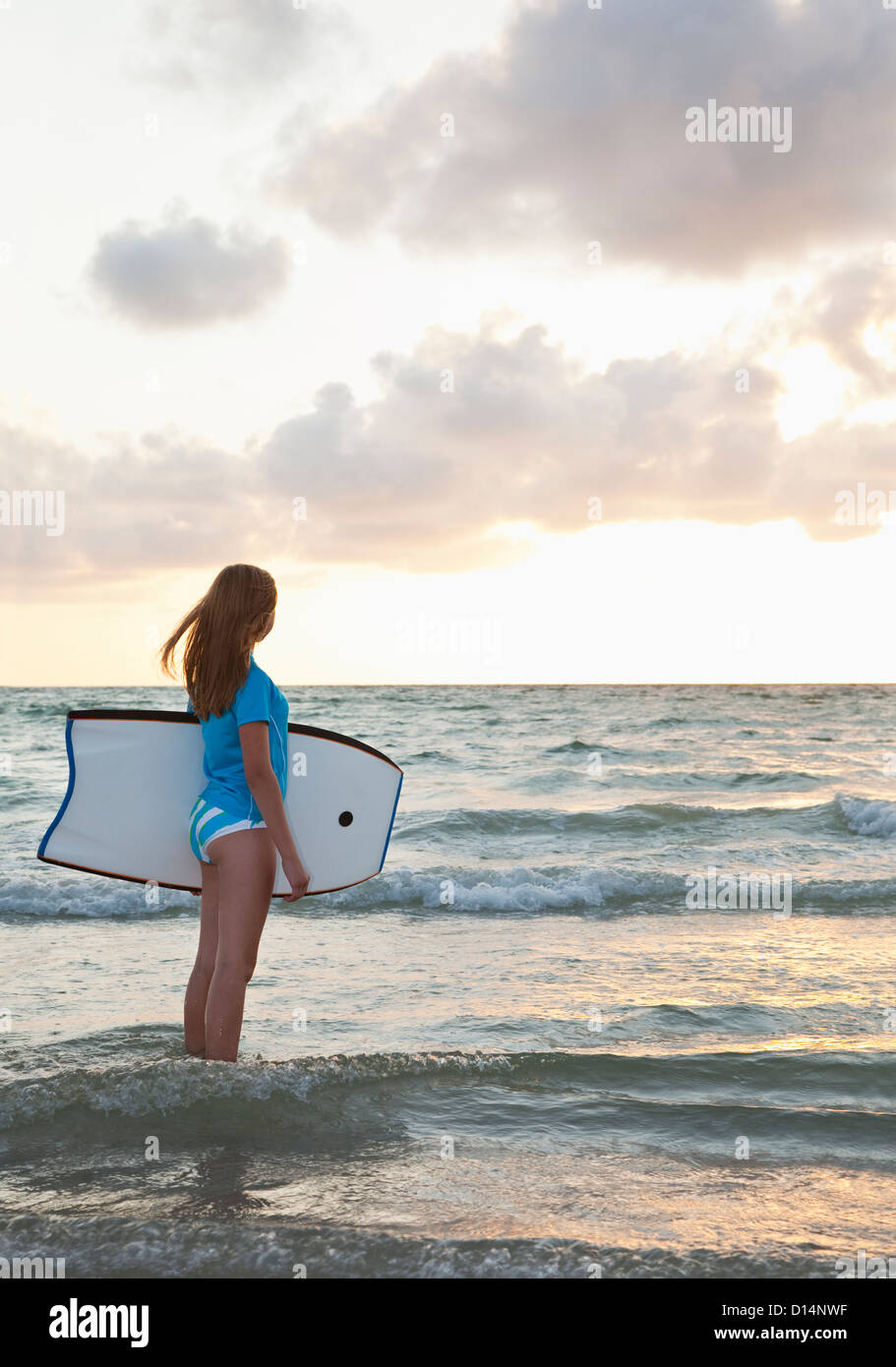 USA, Floride, Saint-Pétersbourg, girl (12-13) holding boogie board et à la vue de Banque D'Images