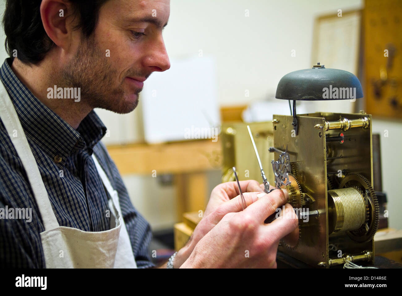 Étudiant travaillant sur une horloge ancienne à West Dean College, près de Chichester, West Sussex, UK Banque D'Images