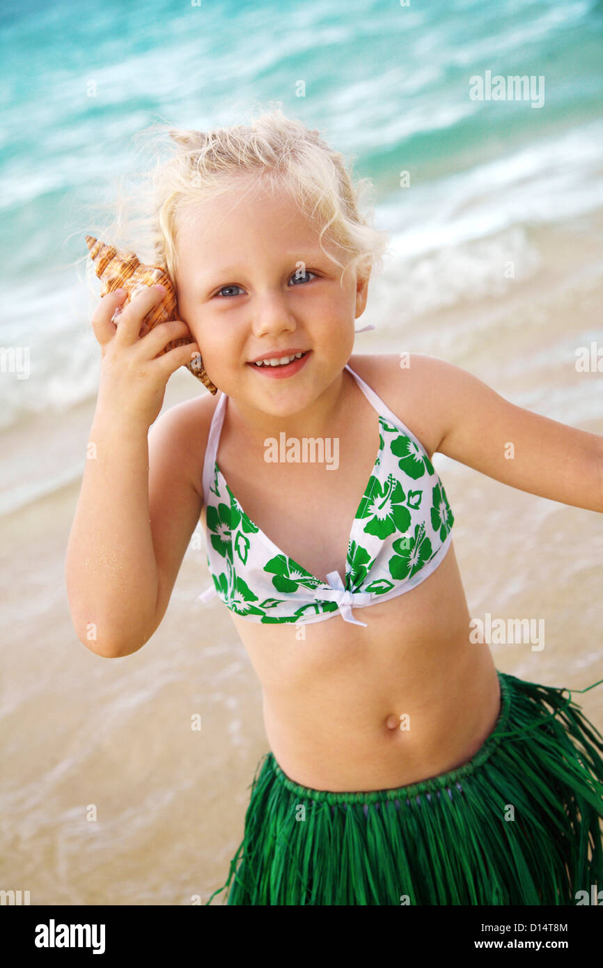 Hawaii, Oahu, jeune fille dans une jupe Hula, l'écoute d'un shell Photo  Stock - Alamy
