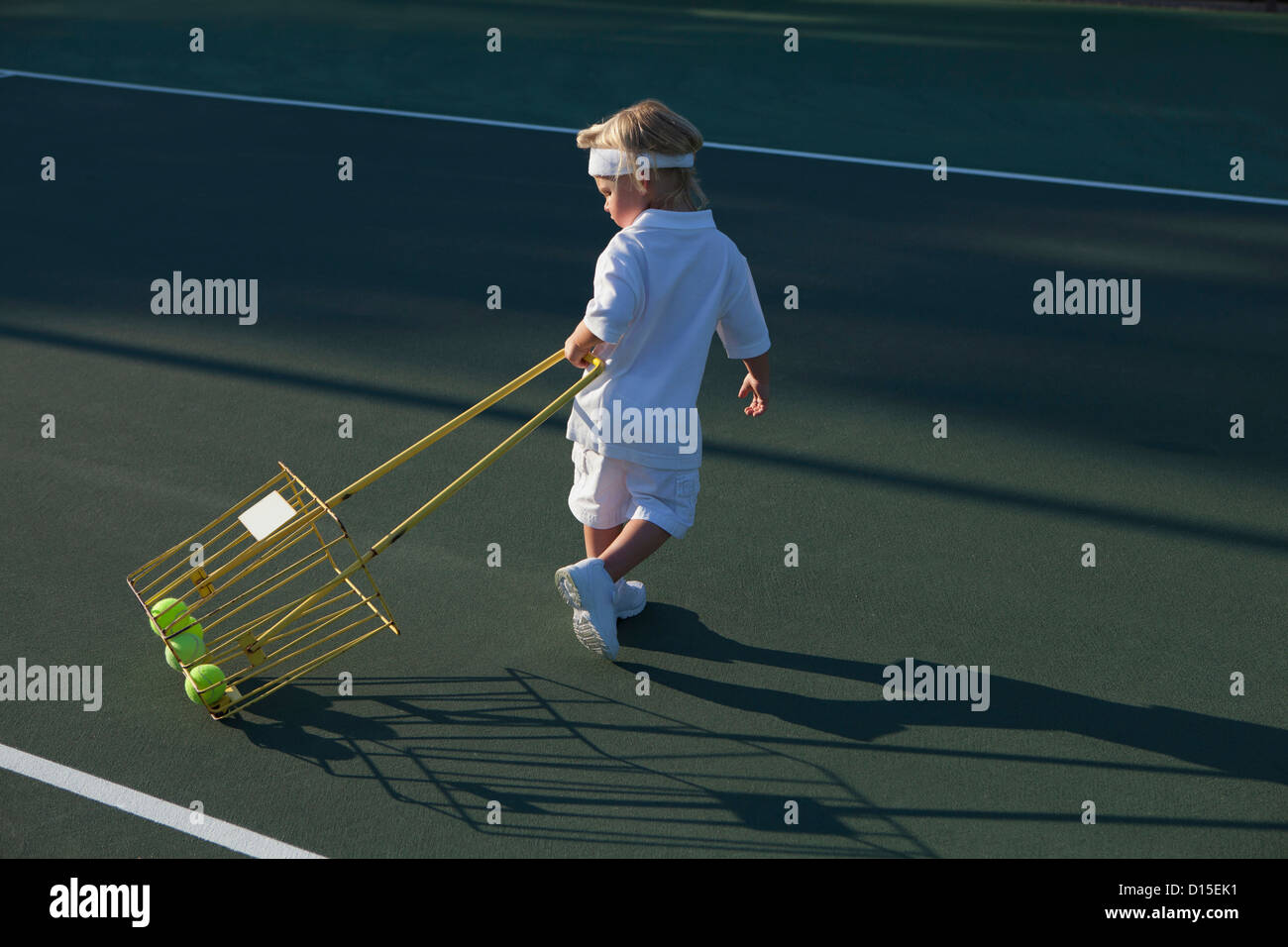 USA, Arizona, Texarkana, Garçon (2-3 ans) en tirant des balles de tennis avec panier Banque D'Images