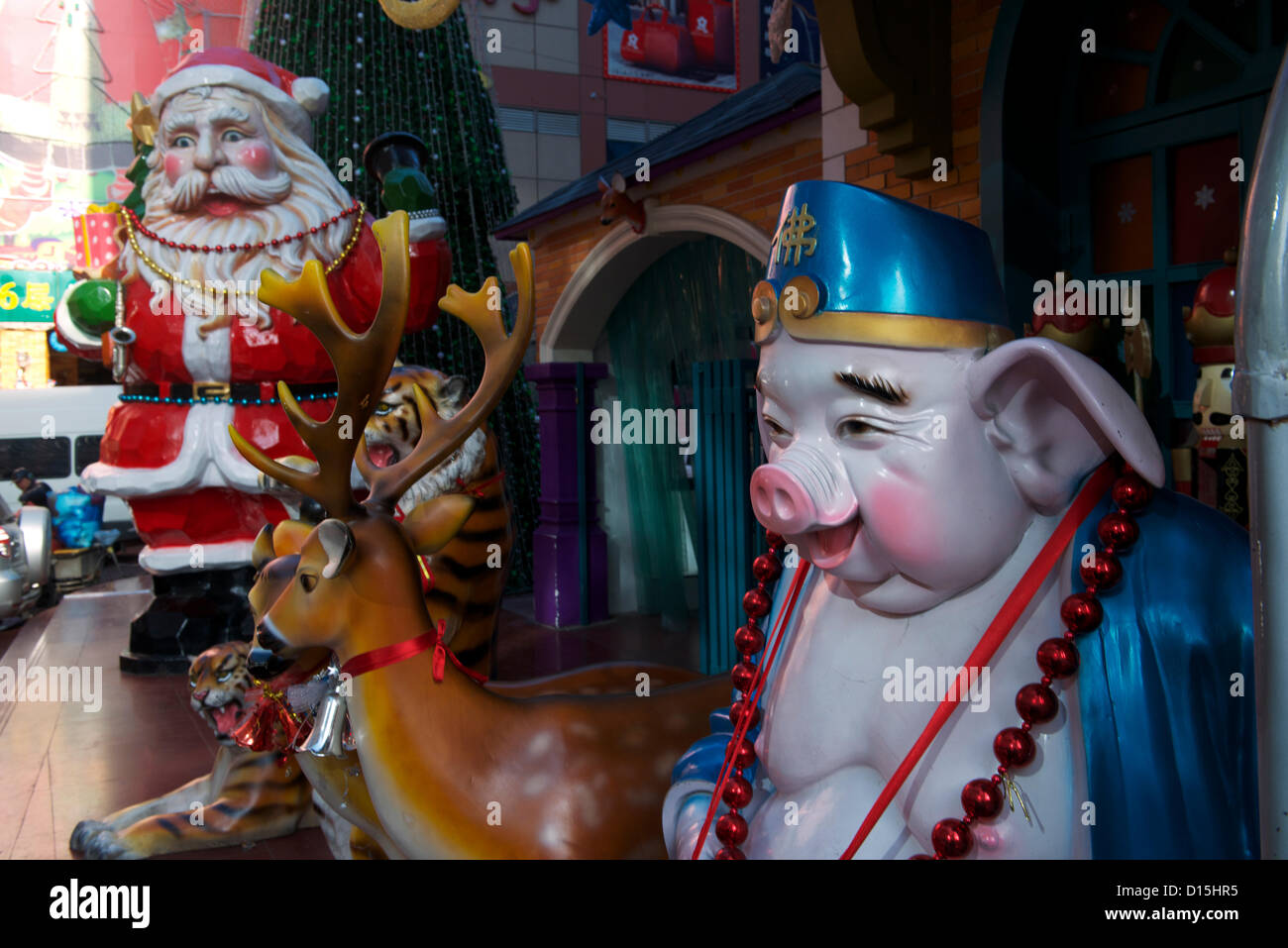 Un énorme Père Noël et une statue de Zhu Bajie(Pigsy ou cochon), qui est l'une des trois aides de Xuanzang dans le roman chinois classique Voyage vers l'Ouest à l'extérieur d'un marché de produits de base le 8 décembre 2012 à Pékin, en Chine. Banque D'Images
