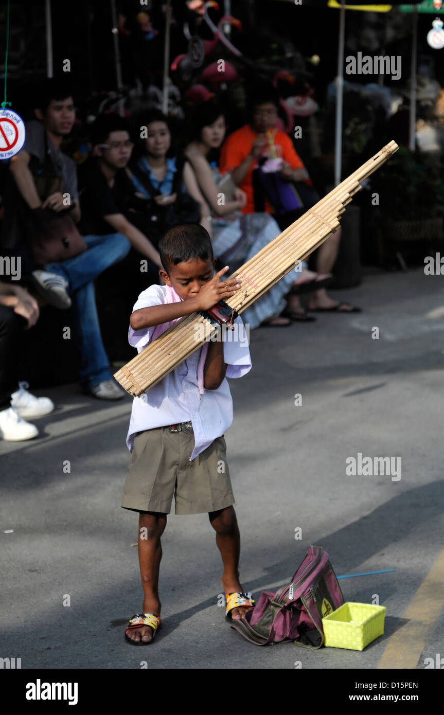 Jeune garçon jouer jouer kaen bouche reed lao-thaïlandaise traditionnelle d'instrument à vent marché Chatuchak Bangkok Thaïlande encore de Banque D'Images