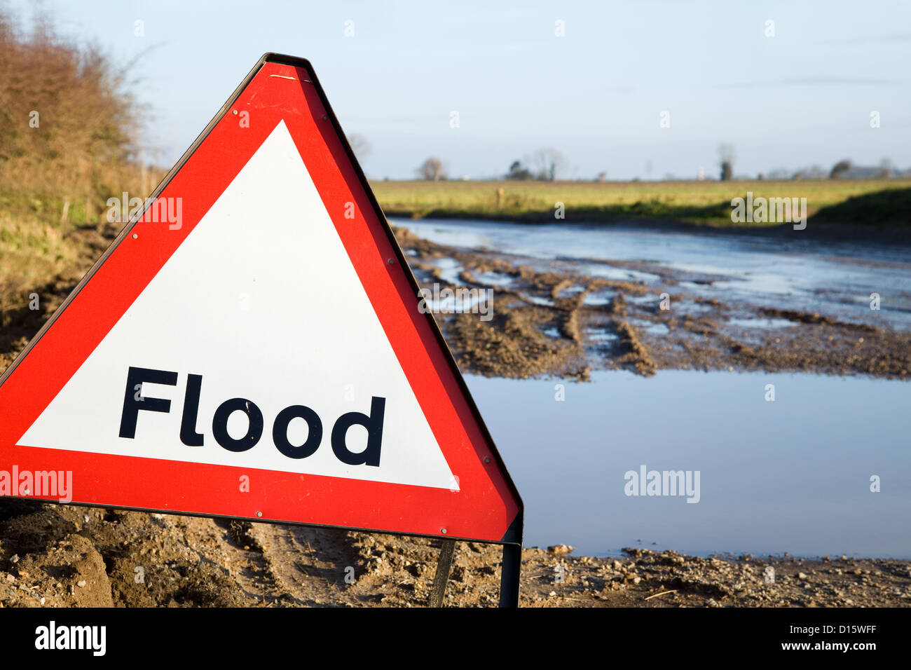 Un avertissement de crue en regard de la route avec les eaux de crue juste derrière elle. Norfolk, Royaume-Uni. Banque D'Images