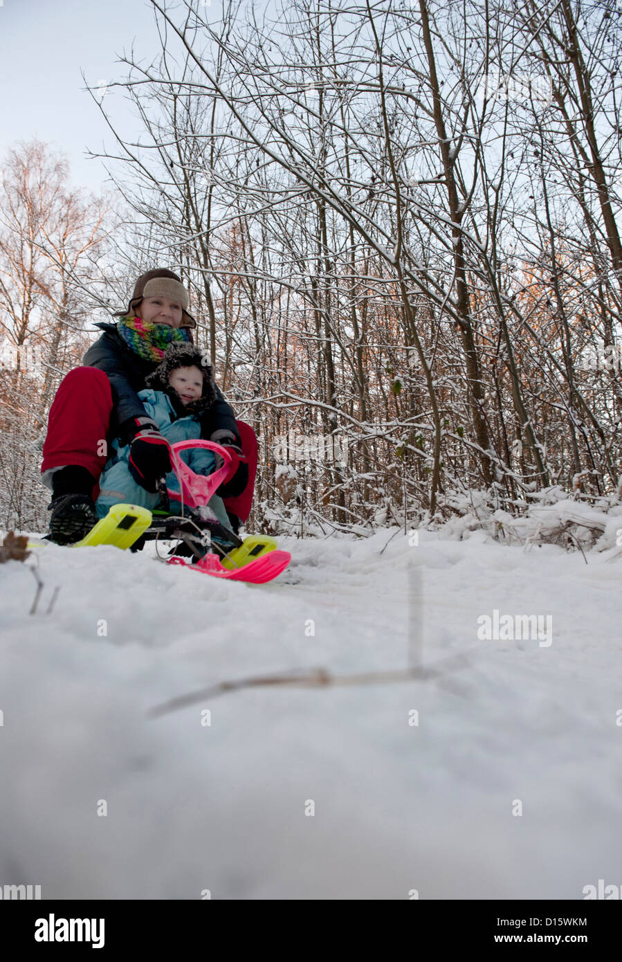 La mère et l'enfant s'amusant avec un traîneau à neige Banque D'Images