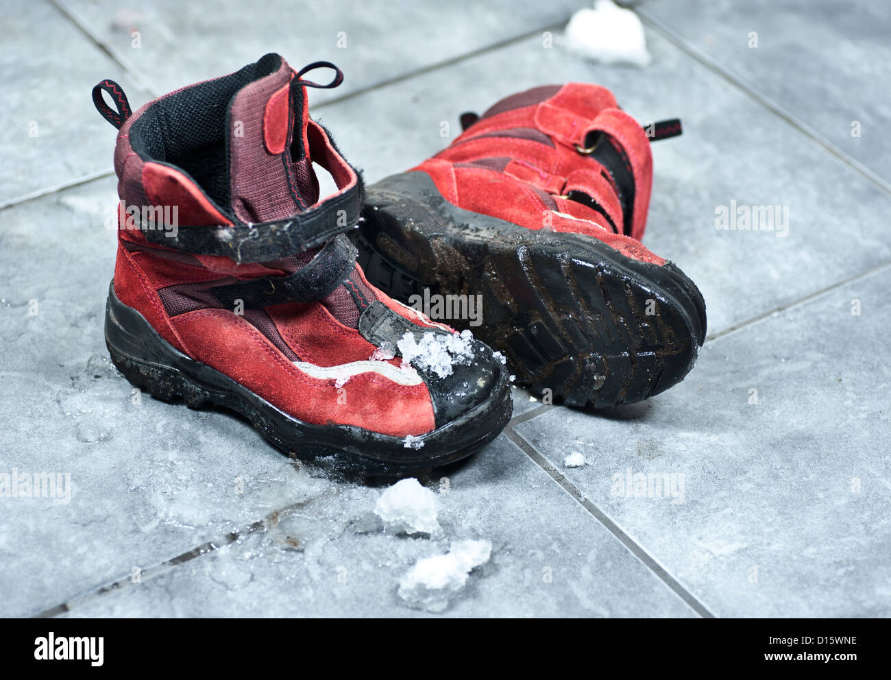 Une paire de chaussures d'hiver plein de neige rendant l'entrée marbre messy Banque D'Images