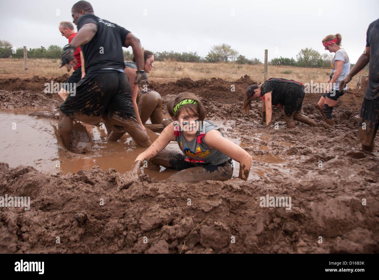 8 décembre 2012 San Antonio, Texas, États-Unis - une femme rencontre l'un des nombreux obstacles boue pendant la Gladiator Rock'n courir à San Antonio. Banque D'Images