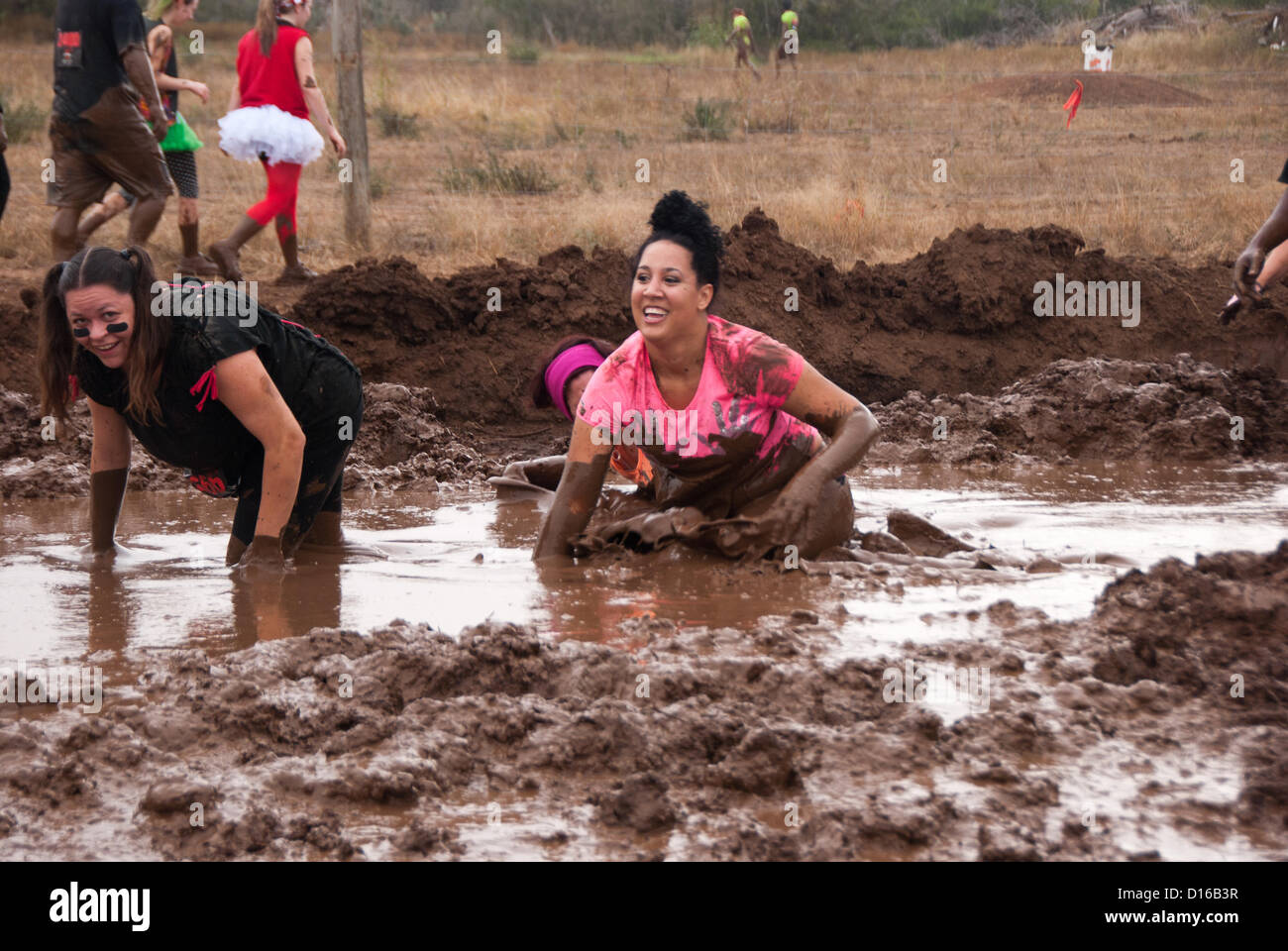 8 décembre 2012 San Antonio, Texas, USA - deux femmes se heurtent à un des nombreux obstacles boue pendant la Gladiator Rock'n courir à San Antonio. Banque D'Images