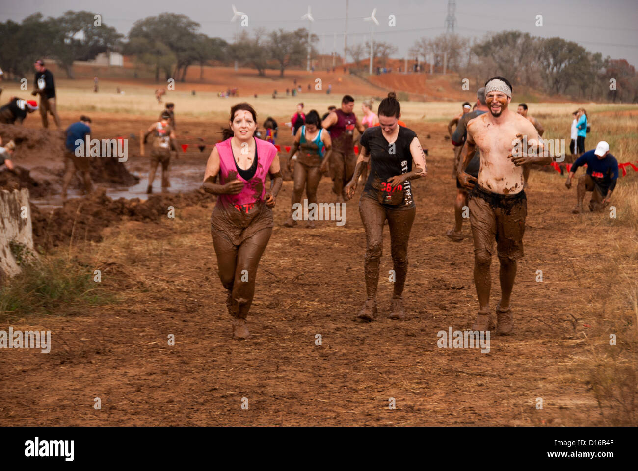 8 décembre 2012 San Antonio, Texas, USA - personnes enfermées dans la boue entre les nombreux obstacles au cours du Gladiator Rock'n courir à San Antonio. Banque D'Images
