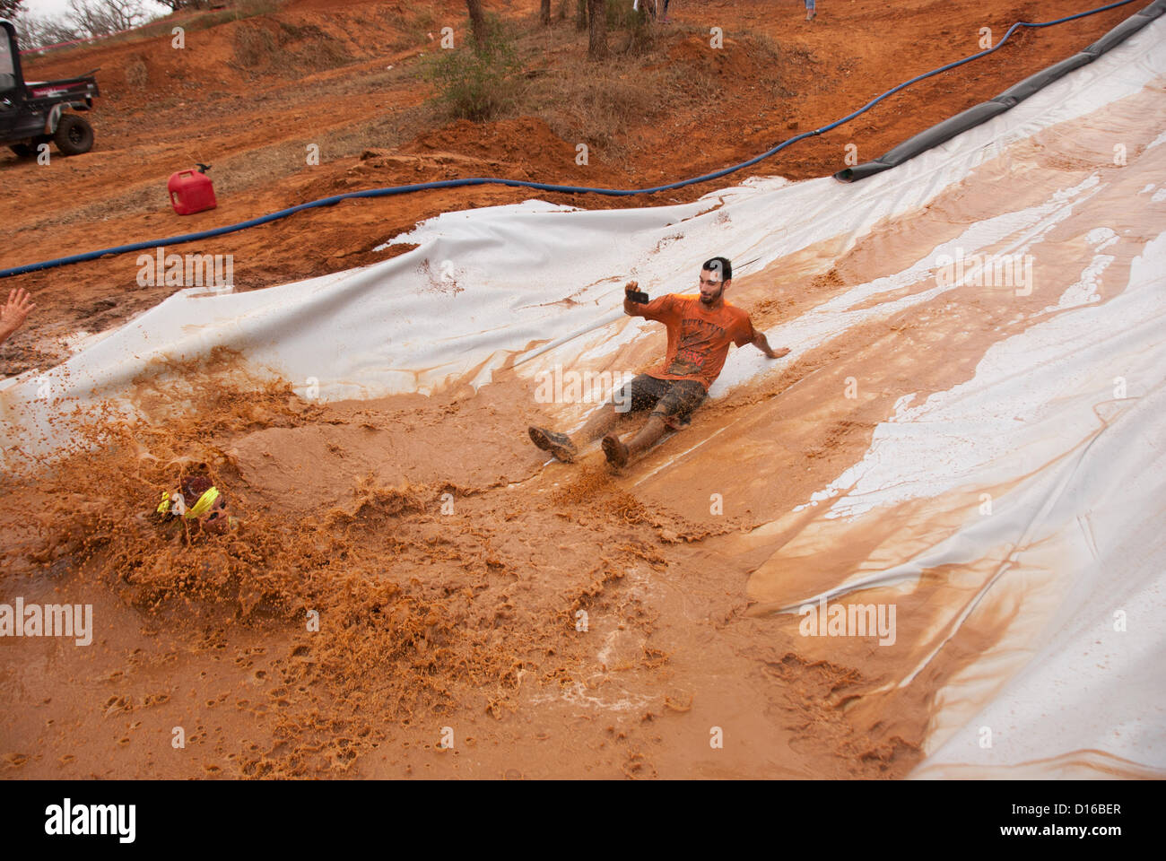 8 décembre 2012 San Antonio, Texas, USA - Les gens glissent sur un obstacle connu sous le nom de 'Skid' pendant le Gladiator Rock'n courir à San Antonio. Banque D'Images