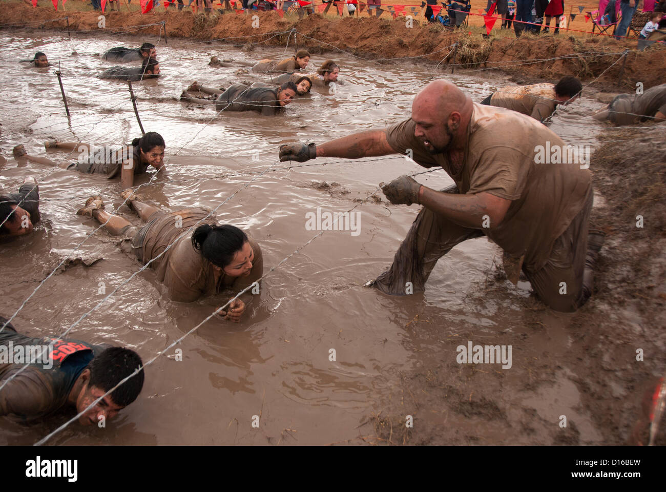 8 décembre 2012 San Antonio, Texas, USA - Les personnes à vaincre l'obstacle de boue pendant le Gladiateur Rock'n courir à San Antonio. Banque D'Images