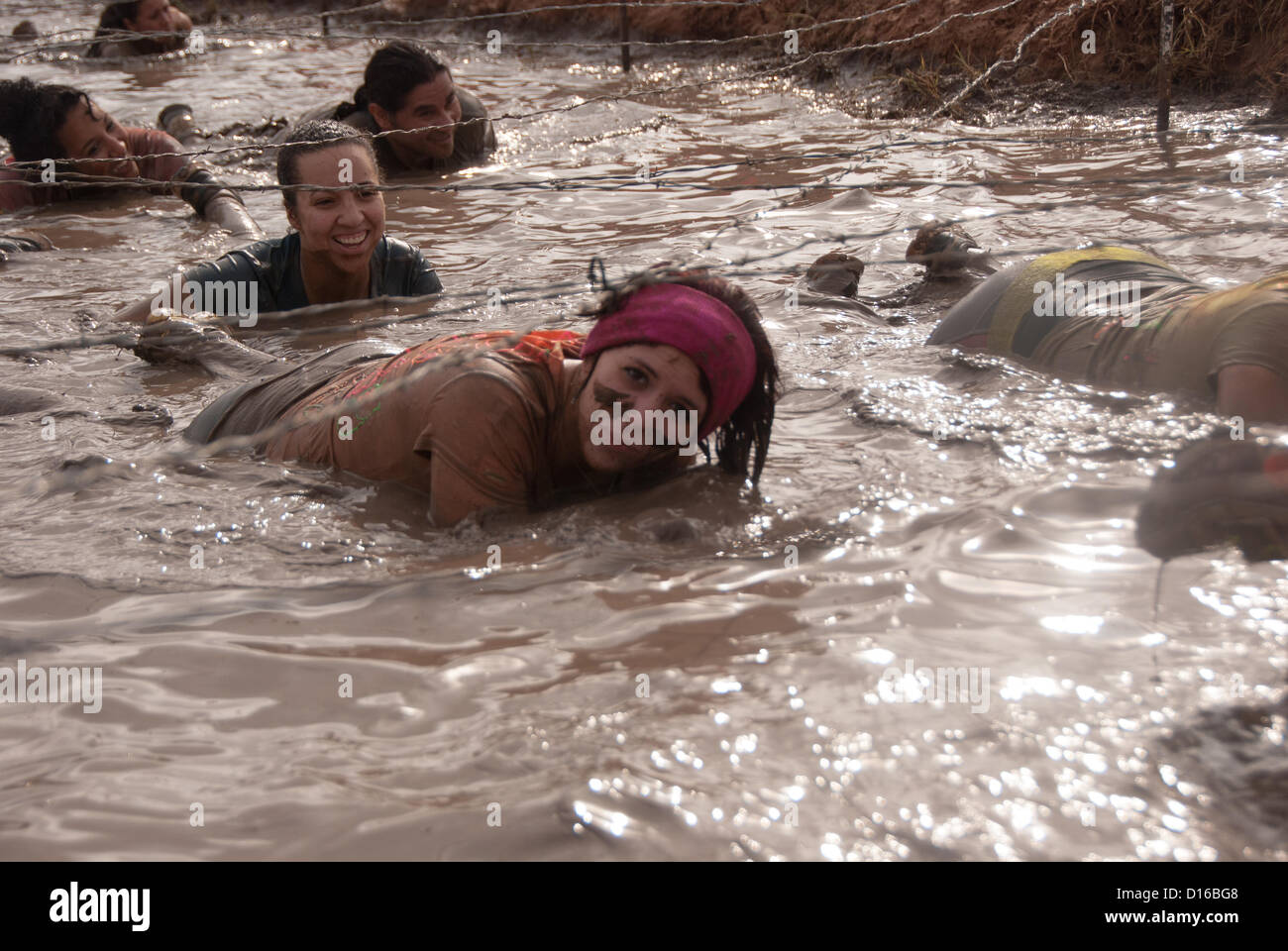 8 décembre 2012 San Antonio, Texas, États-Unis - Une femme de San Antonio à boue conquiert l'obstacle pendant le Gladiateur Rock'n courir à San Antonio. Banque D'Images