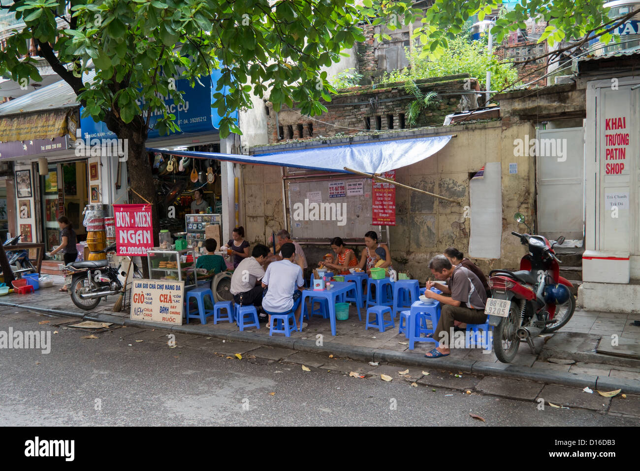 Street food Vietnam style. Pris dans la vieille ville d'Hanoi habitants profiter de bols de nouilles. Banque D'Images