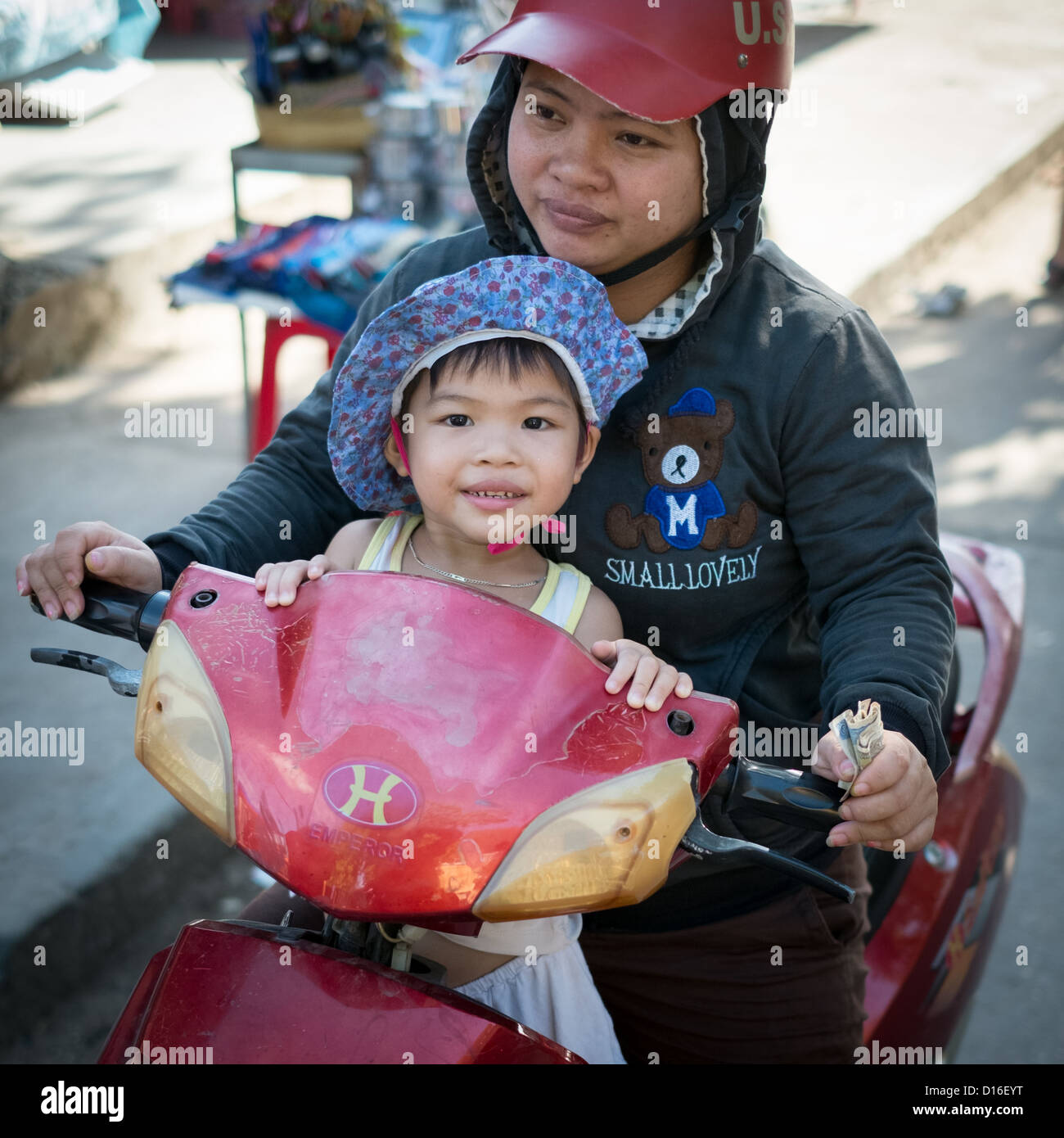 Les jeunes enfant vietnamien sur les mères lap sitting on scooter Banque D'Images