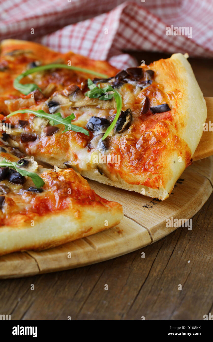 Pizza italienne avec des champignons et des olives sur une planche en bois Banque D'Images