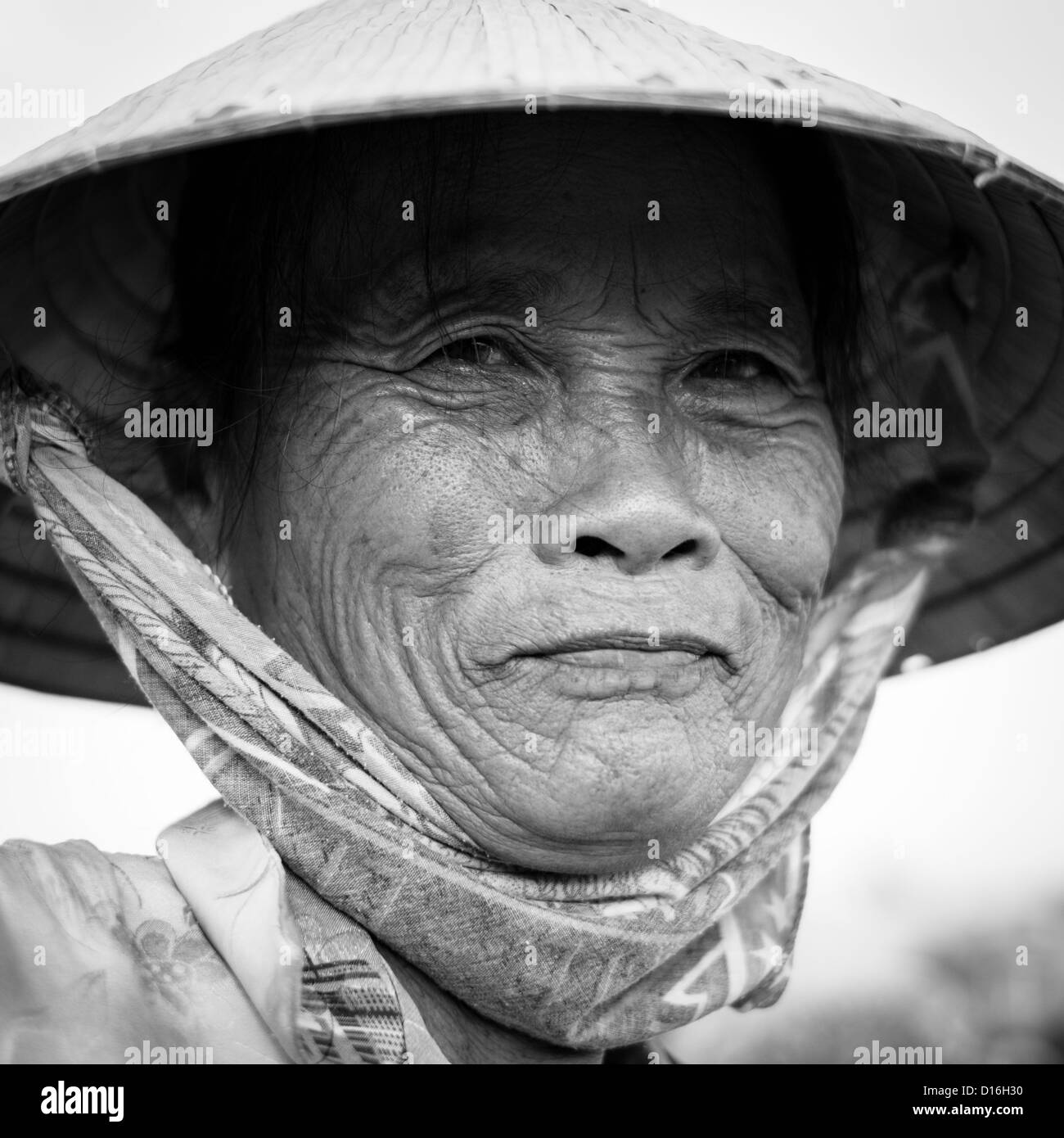 Portrait noir et blanc d'une vietnamienne portant un chapeau de bambou traditionnel Banque D'Images