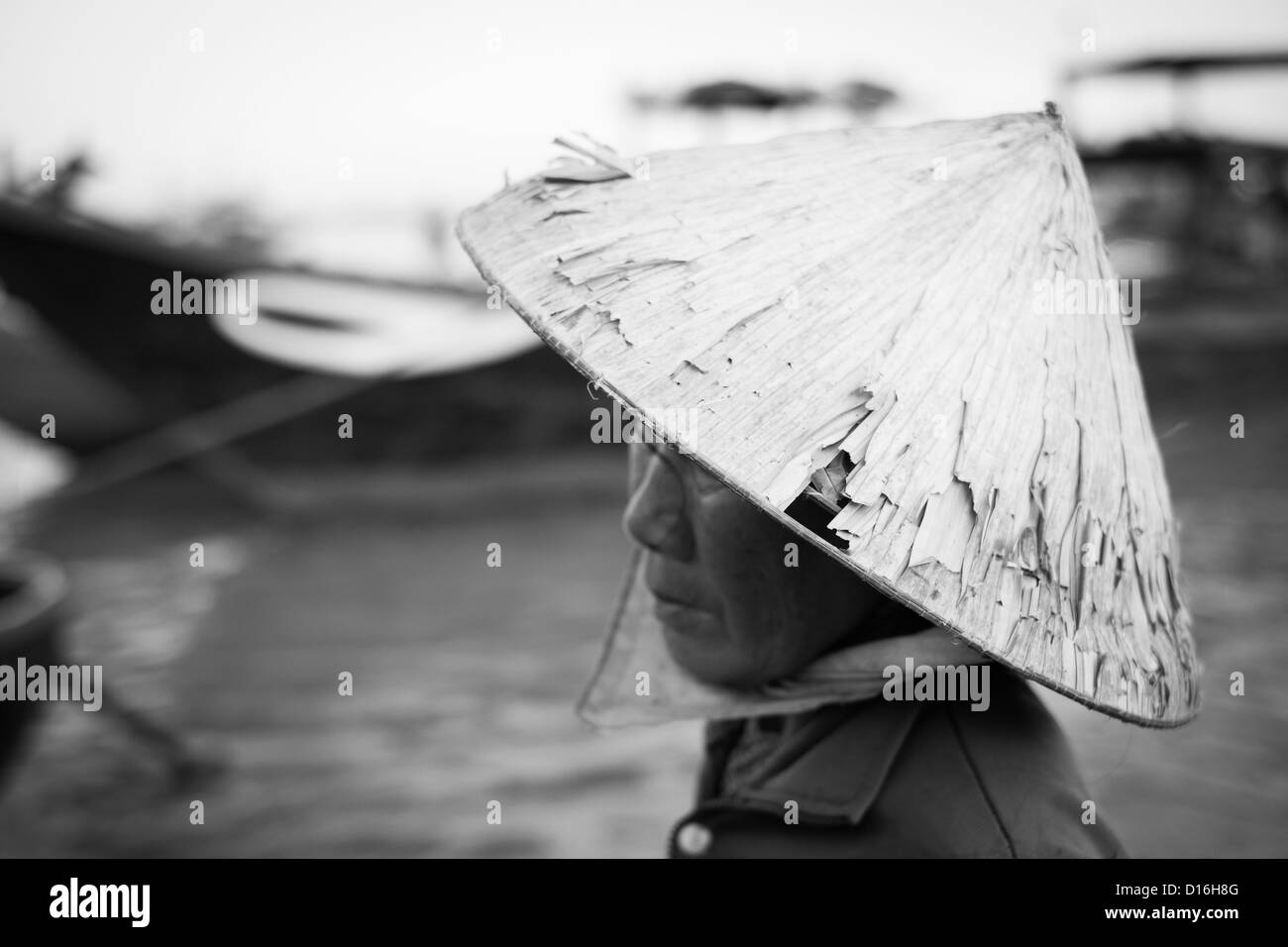 Femme portant une Vietnamienne traditionnelle, mais plutôt tatty bamboo hat Banque D'Images